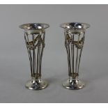 A pair of Edward VII silver vase holders pierced tapered form with floral swags on circular bases,