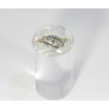 A diamond five stone crossover ring, set in platinum with foliate surrounds, on a yellow 18ct gold
