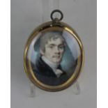 Attributed to William Dudman, a 19th century oval miniature portrait of a young man with grey