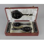 A cased George V silver and tortoiseshell dressing table set to include a hand mirror and two