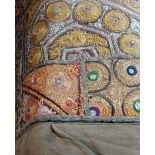 An Eastern embroidered patchwork wall hanging made from purses, with brass rings 84cm by 155cm