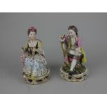 A pair of Meissen style porcelain figures of a gentleman reading and a lady sewing 14cm high (a/f)