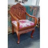 An Eastern carved hardwood armchair with drop in upholstered seat on cabriole legs