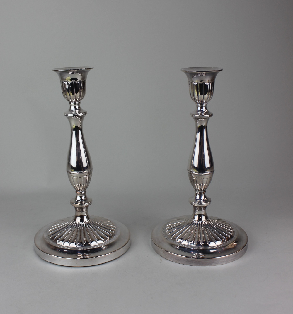 A pair of silver plated candlesticks baluster stems on fluted circular bases, 24cm