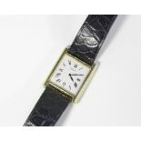 Piaget, a gold wristwatch the rectangular case with Roman numerals on leather strap with