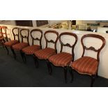 A set of six Victorian rosewood balloon back dining chairs with overstuffed seats on cabriole legs