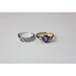 An aquamarine three stone ring with tiny diamond shoulders in white gold; an amethyst ring with