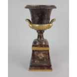 A marble effect metal model of an urn on plinth base, with gilt embellishments 31cm high