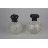 An Edward VII silver topped glass perfume bottle with stopper and scroll embossed top and another