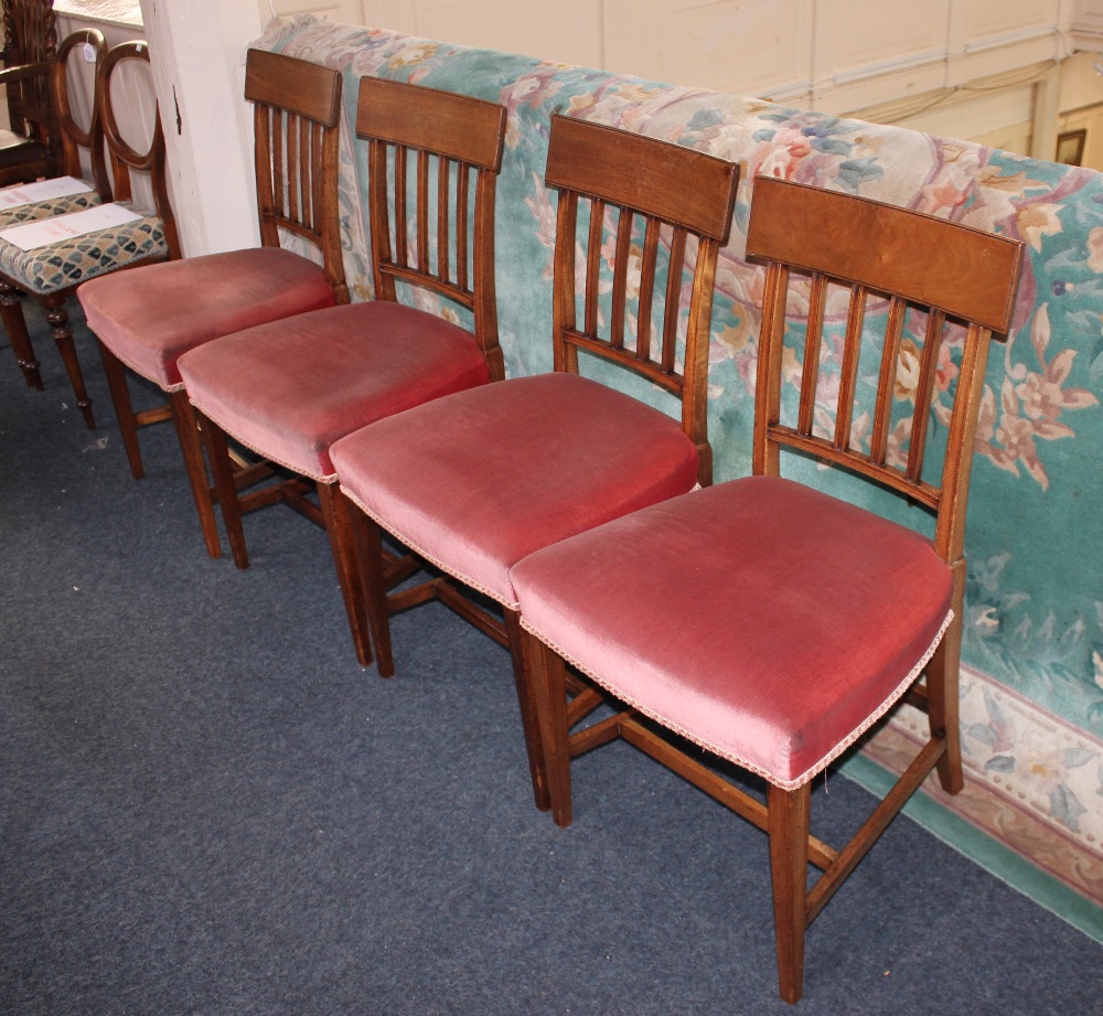 A set of four Sheraton style mahogany dining chairs with curved top rail above a five bar back,