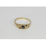 A sapphire three stone crossover ring with foliate surround, the centre stone flanked by two old cut