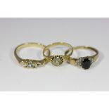 A 9ct gold sapphire and diamond ring, three stone gilt metal ring and a cluster ring