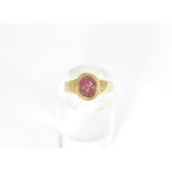 An 18ct gold intaglio hardstone ring with oval cabochon red stone