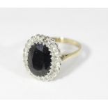 A dark sapphire and diamond cluster ring, in an illusion setting on a 9ct gold shank