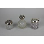Two early 20th century silver topped dressing table jars and perfume bottle (a/f)