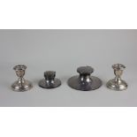 An early 20th century silver capstan inkwell another smaller inkwell and a pair of George V silver