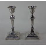 A pair of Edward VII silver candlesticks urn sconces with drip trays on fluted baluster stems and