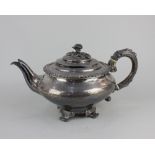A George III silver teapot circular shape with dome lid and floral cast finial and scroll handle,