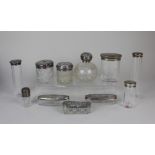 A collection of eleven early 20th century silver topped glass dressing table jars and bottles (a/f)