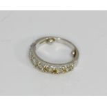 A diamond seven stone half hoop ring set in 18ct white gold with two sizing beads attached to shank