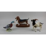 A Beswick model of a basset hound 14cm high, together with two Goebel porcelain models of a goat