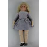 A Kathe Kruse girl doll with painted brown eyes, closed mouth and blonde hair 49cm high