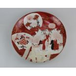 A Japanese Kutani porcelain plate decorated with panels of figures and flowers, character marks