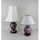 Two similar modern ceramic table lamps in the form on ginger jars on wooden stands, each decorated