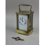 A French brass and bevelled glass cased carriage clock, striking on a gong, 18cm high, with key