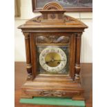 A Junghans carved oak mantle clock the dial with Arabic numerals, chiming on rods 45cm high, with