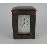 A French brass and bevelled glass cased carriage clock the white enamel dial with Roman numerals,