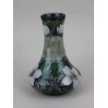 A Cobridge stoneware Mexican Orange blossom vase, with floral decoration on blue mottled ground 18.