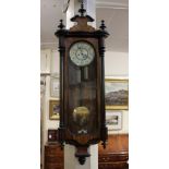 A late 19th century walnut Vienna wall clock, the pediment with turned finials above single glazed