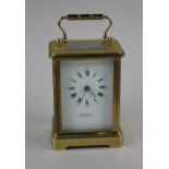 A brass and bevelled glass cased carriage clock with key