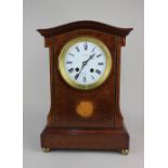 A 19th century French inlaid walnut mantle clock, the circular white enamel dial with Roman numerals
