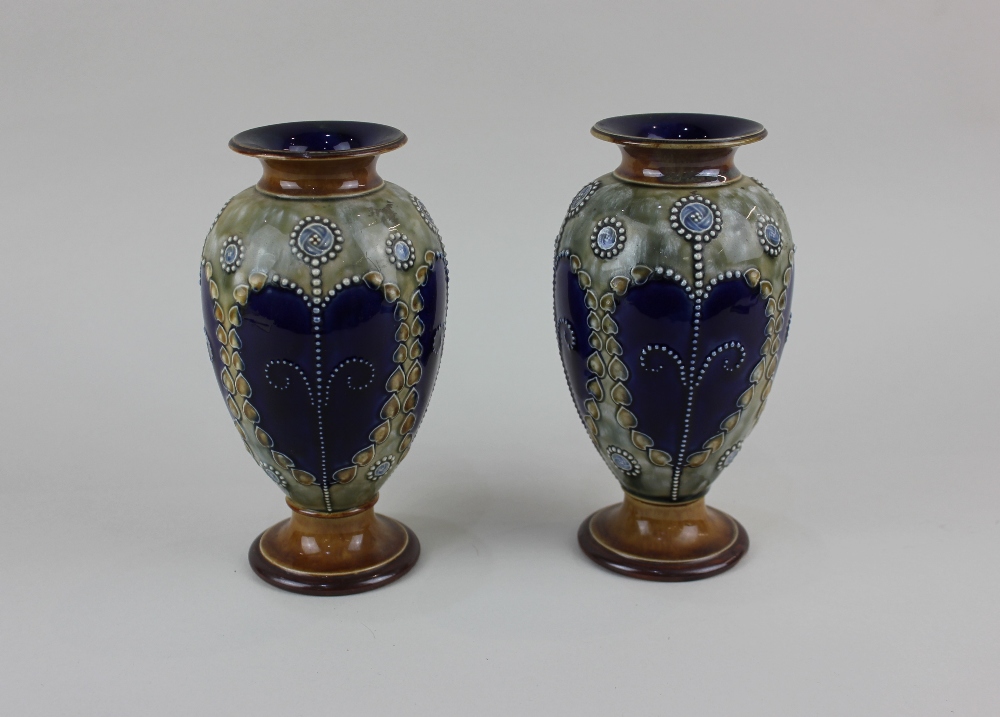 A pair of Royal Doulton glazed stoneware baluster vases with beaded and tube lined repeat decoration