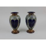 A pair of Royal Doulton glazed stoneware baluster vases with beaded and tube lined repeat decoration