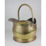 A brass coal scuttle with carry handle