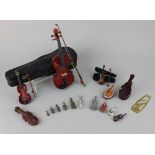 A collection of miniature violins and a miniature violin case, to include three wooden models, two