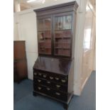 A George III bureau bookcase later bookcase top with two glazed doors enclosing three shelves on