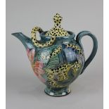 A studio pottery teapot decorated with leopards amongst foliage and flowers, with sinuous applied