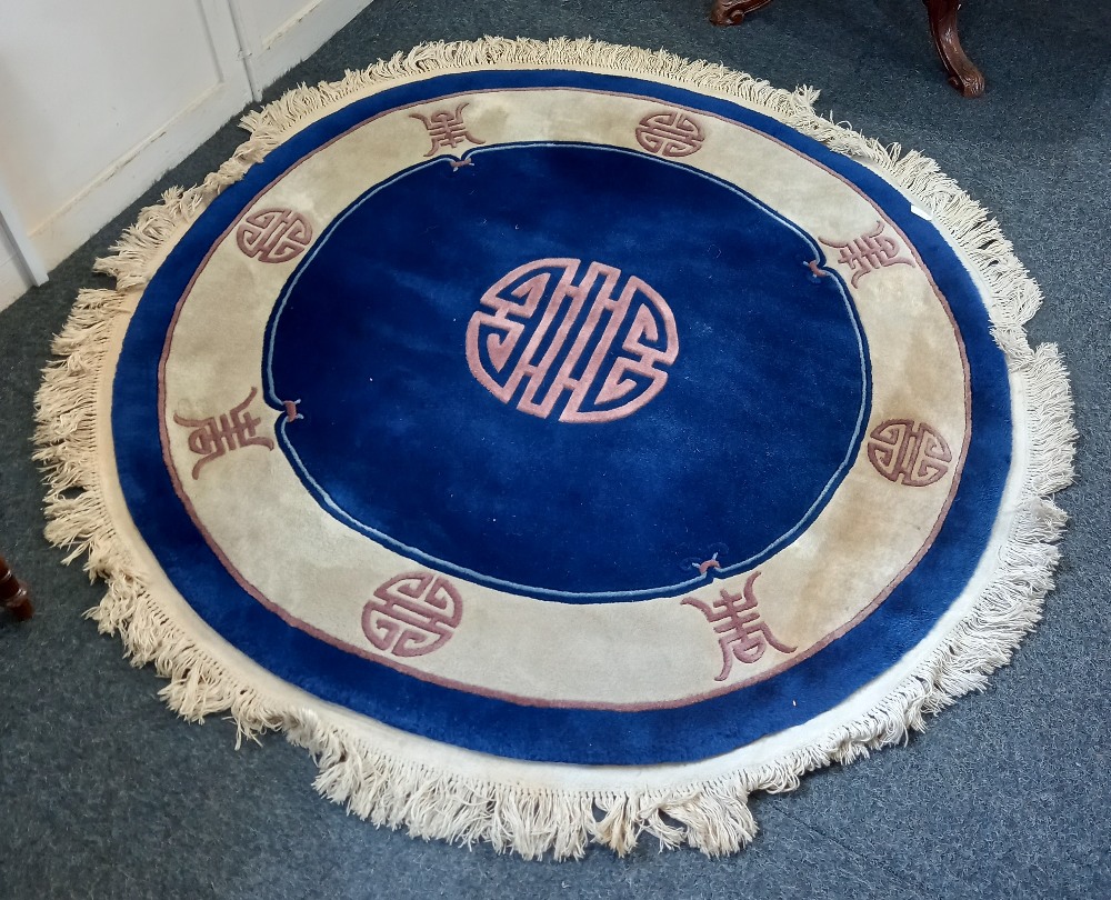 A Chinese circular rug blue field with calligraphic motif centre and border, 162cm