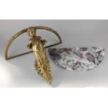 A Baroque style marble and gilt metal demi lune wall shelf with cast cherub support 44.5cm