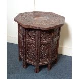 A Moorish carved circular occasional table deeply carved floral top on octagonal pierced folding