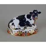 A Royal Crown Derby Imari porcelain paperweight of a Friesian Cow 'Buttercup', with gold stopper