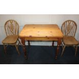 A small rectangular pine table on baluster legs 82cm and two wheel back dining chairs