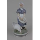 A Royal Copenhagen porcelain figure of a girl standing with a goose marked no 527 to base 24cm high