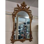 A gesso and giltwood framed wall mirror surmounted with a flower filled urn and pierced scrolling