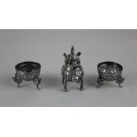 A Chinese white metal three piece cruet set the mustard pot in the form of a dragon with spoon and