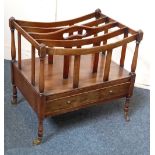 A mahogany canterbury four divisions with central handle, base drawer, on turned legs and castors,